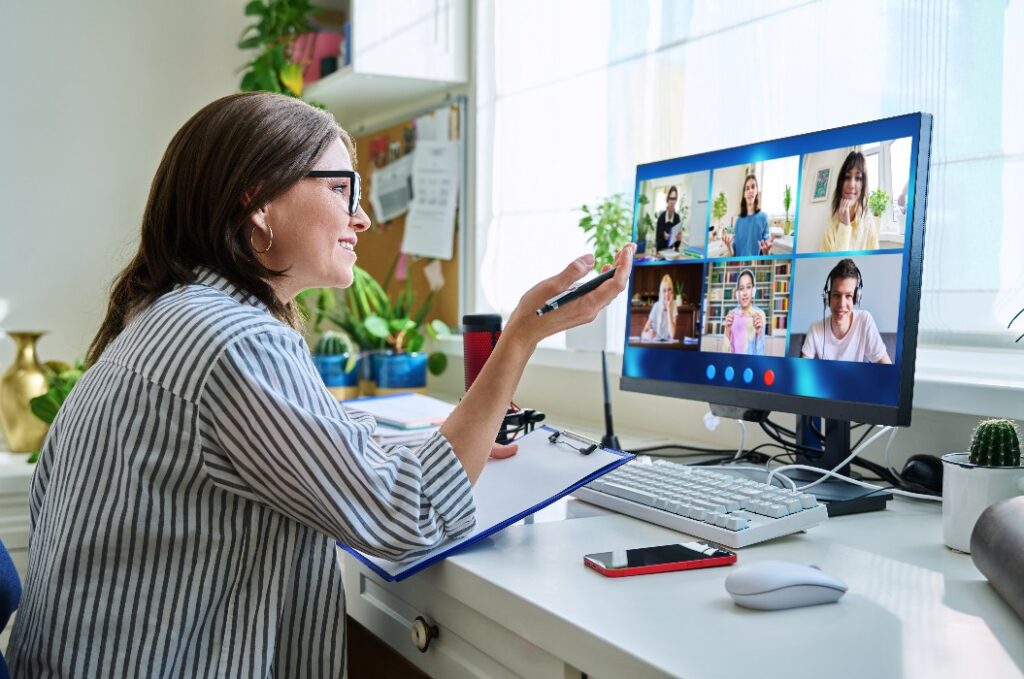 Lehrerin bei der Arbeit zu Hause, Online-Unterricht mit einer Gruppe von Teenagern